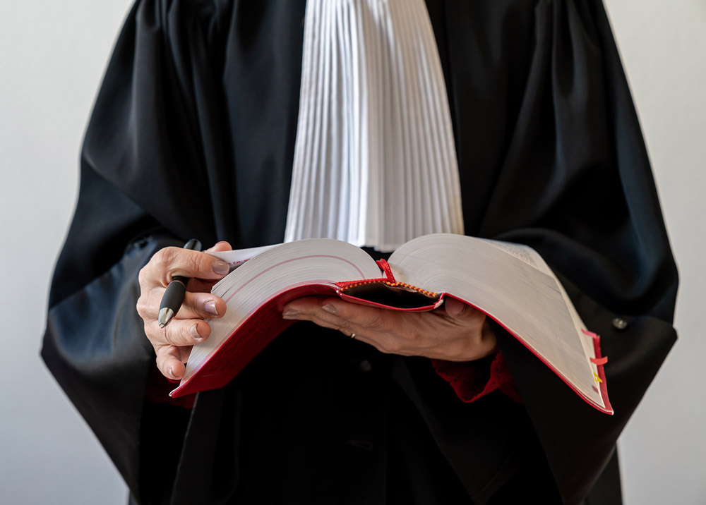 Avocat dans sa robe avec un livre de droit